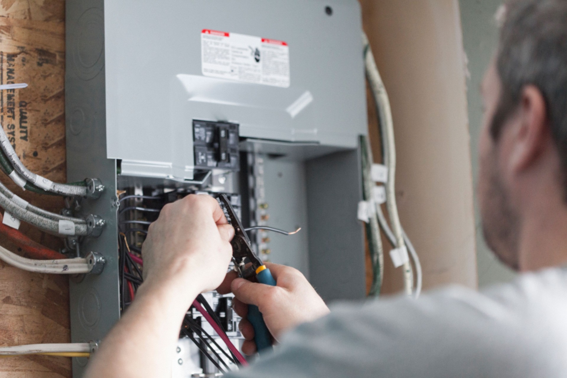 Electricista actualizando el tablero de distribución de una casa